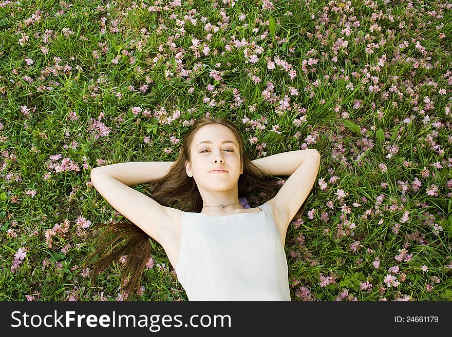 Beautiful woman lying on a garden of flowers and smiling. Beautiful woman lying on a garden of flowers and smiling