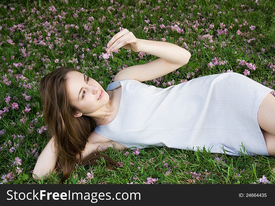 Happy young woman lying on green grass