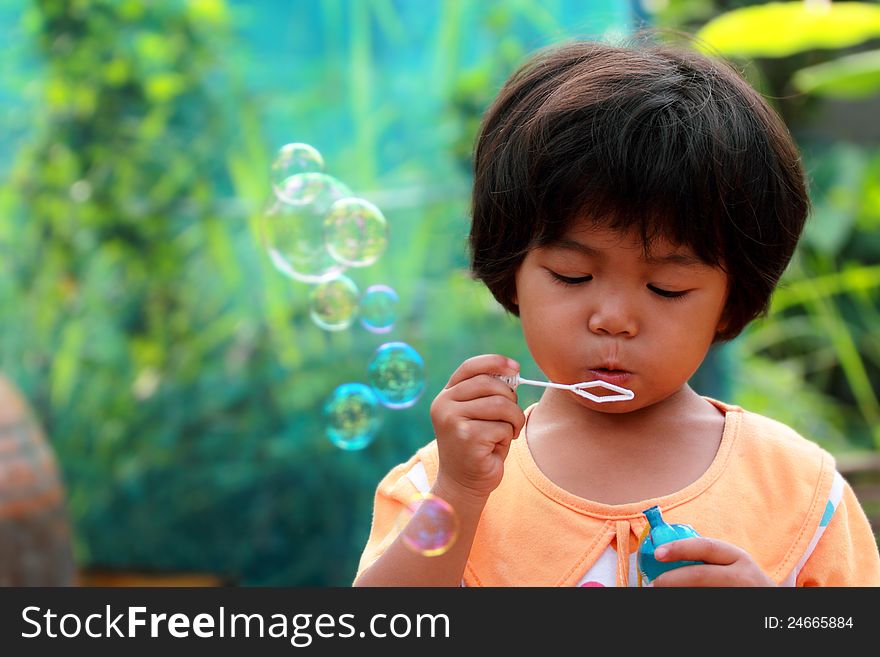 Thai little girl blowing bubbles