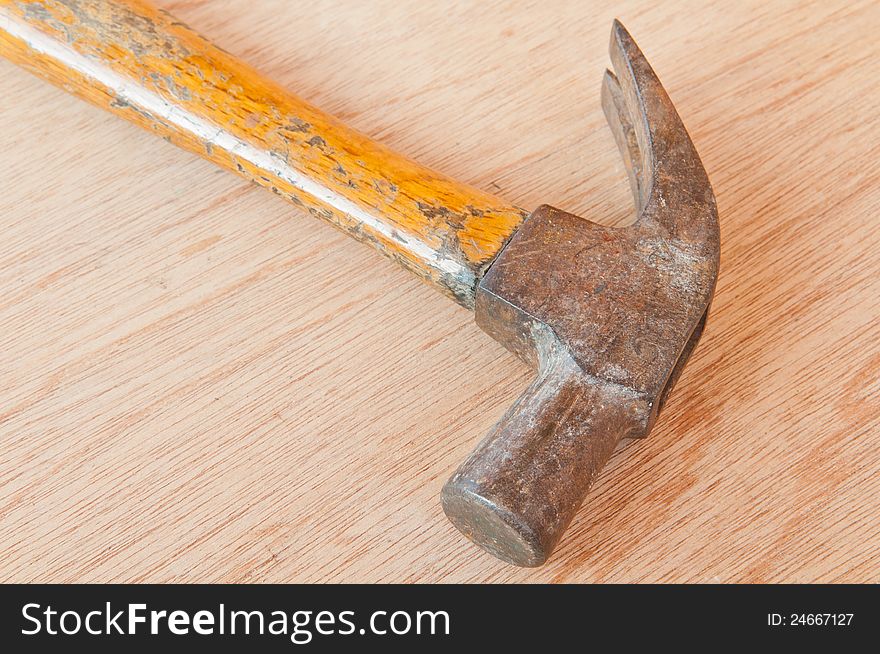 Old hammer on wood background