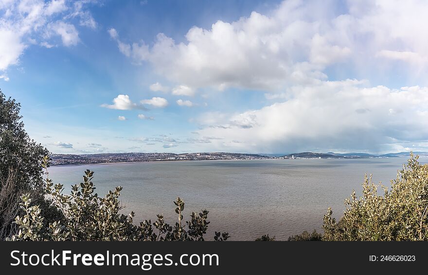 View From Mumbles Hill Over Swansea Bay, With Cloudy Blue Sky And The Tide Is In.