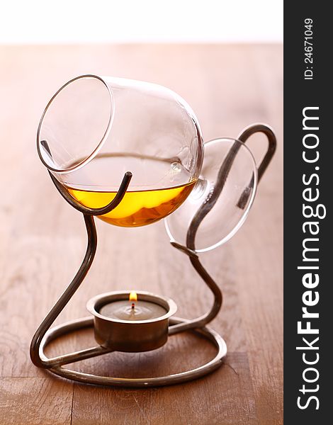 Glass of hot cognac over wooden surface