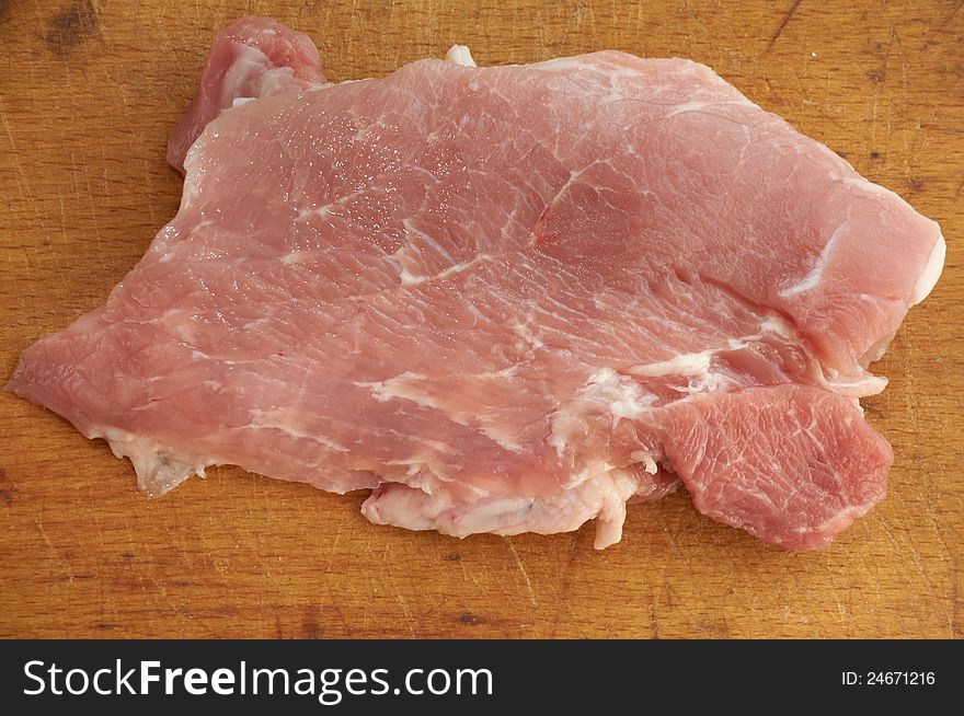 Piece of fresh pork on an old chopping board