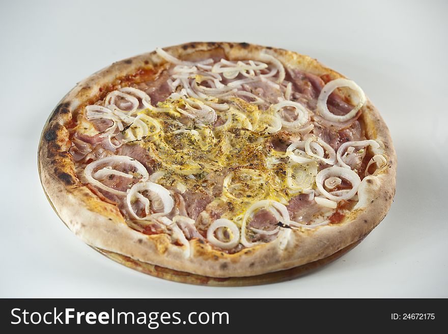 Pizza with onion rings, ham and scrambled egg.