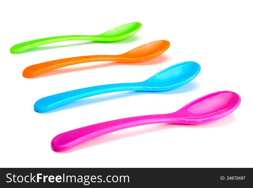 Little empty colorful spoons in white background.