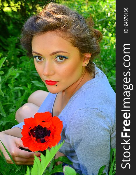 Image of a beautiful girl next to a red flower. Image of a beautiful girl next to a red flower