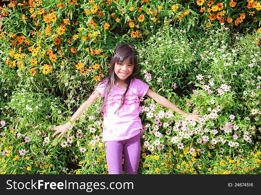 Smiling little girl laying on flower field