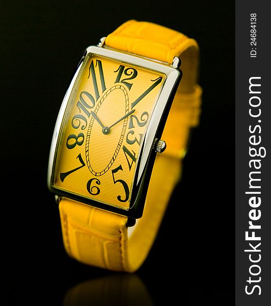 Elegance design of woman yellow wristwatch on black background