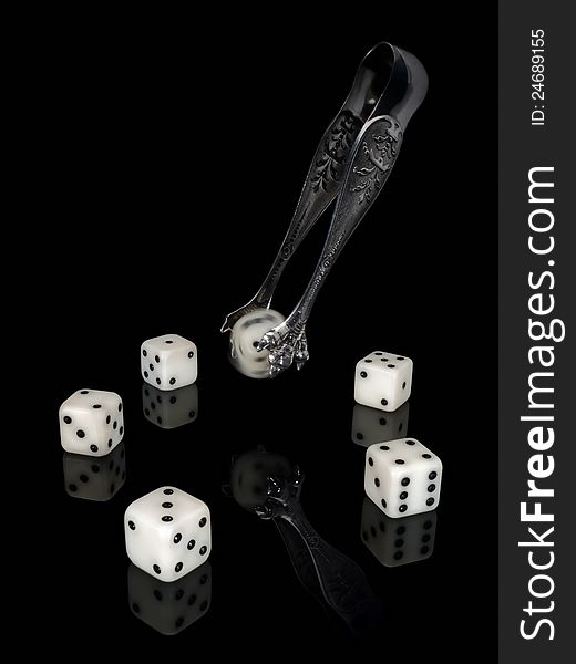 Dice and ancient silver nippers on a black background. Dice and ancient silver nippers on a black background.