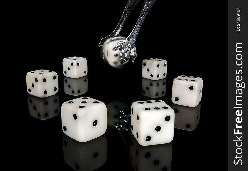 Dice and ancient silver nippers on a black background. Dice and ancient silver nippers on a black background.