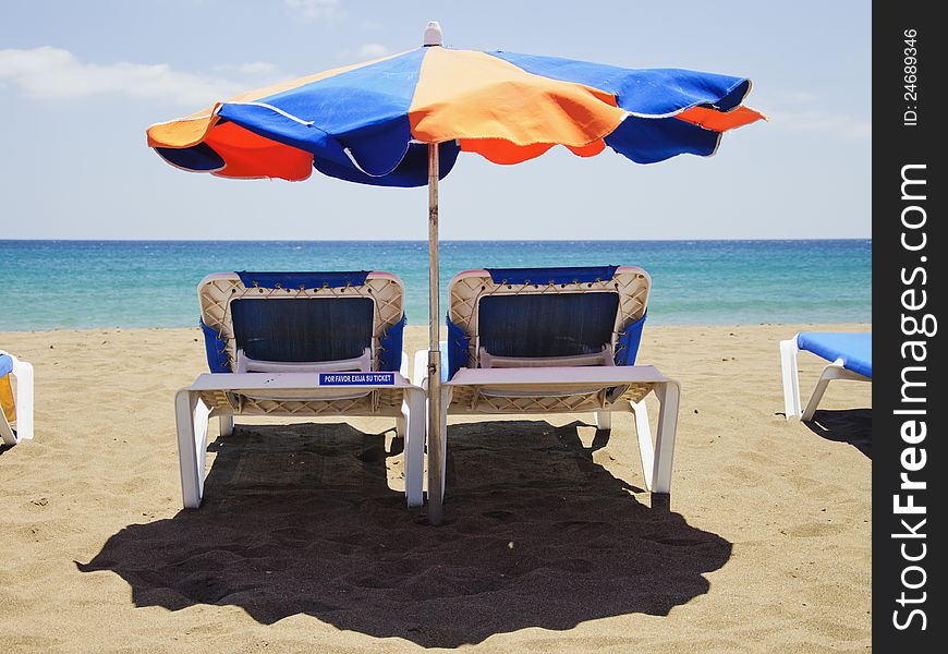 Beach umbrella and deckchairs