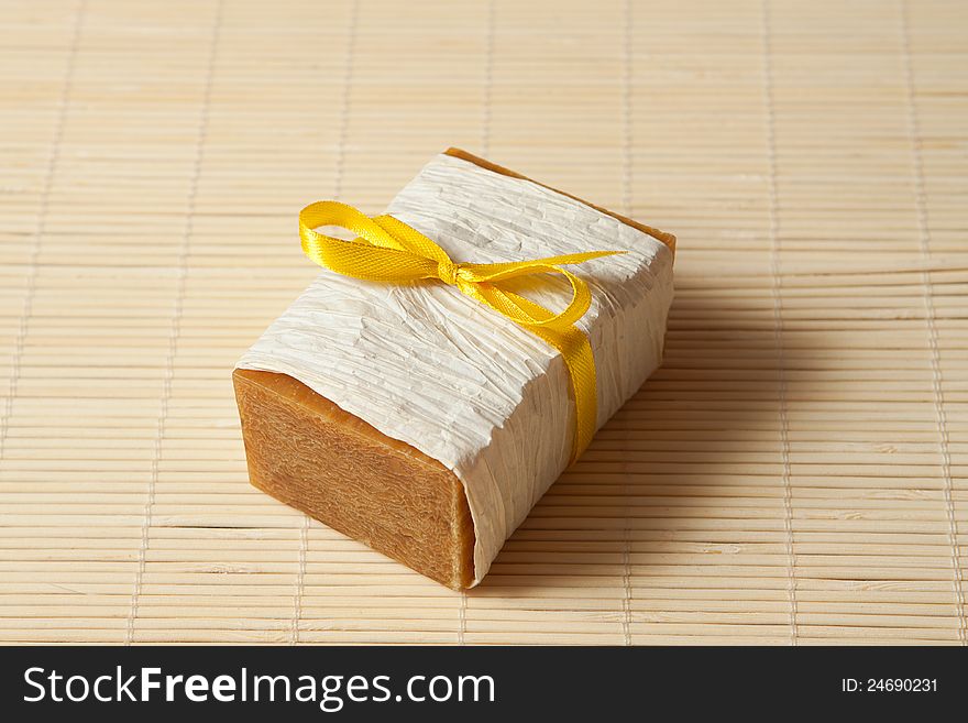 Natural soap tied with a ribbon on a bamboo mat