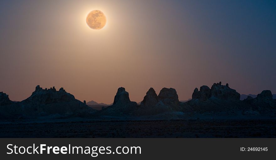 Super moon rises over basalt pinnacles in California's high desert. Moon light scatters in the dusty air creating an array of colors. Super moon rises over basalt pinnacles in California's high desert. Moon light scatters in the dusty air creating an array of colors.