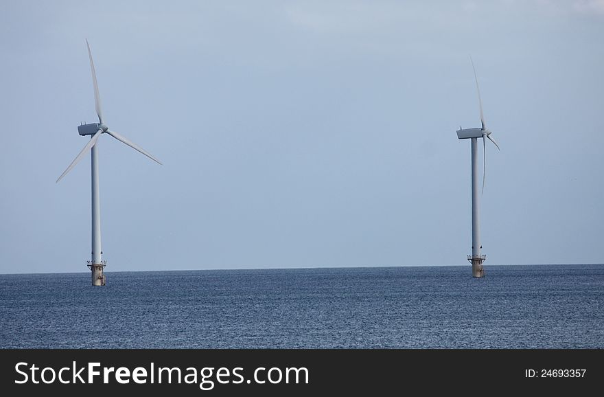 Two Wind Turbine Towers Standing in the Sea. Two Wind Turbine Towers Standing in the Sea.