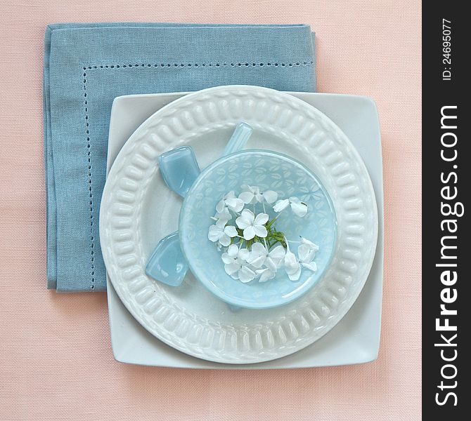 Table place setting in pink and blue with flowers