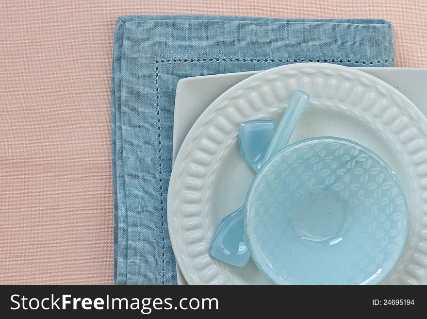 Table place setting in blue and pink with white crockery