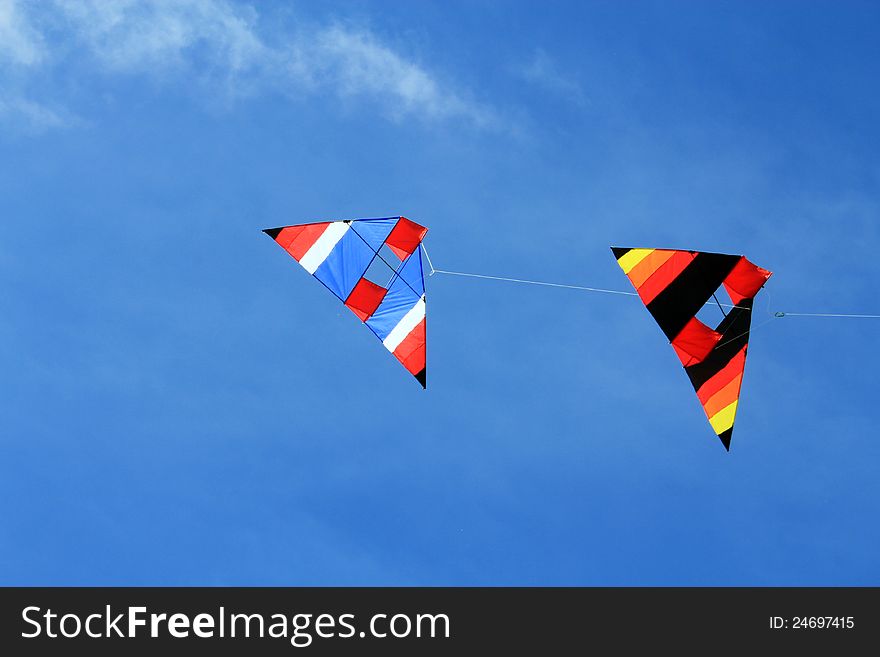 Two triangle kites flying in the sky. Two triangle kites flying in the sky