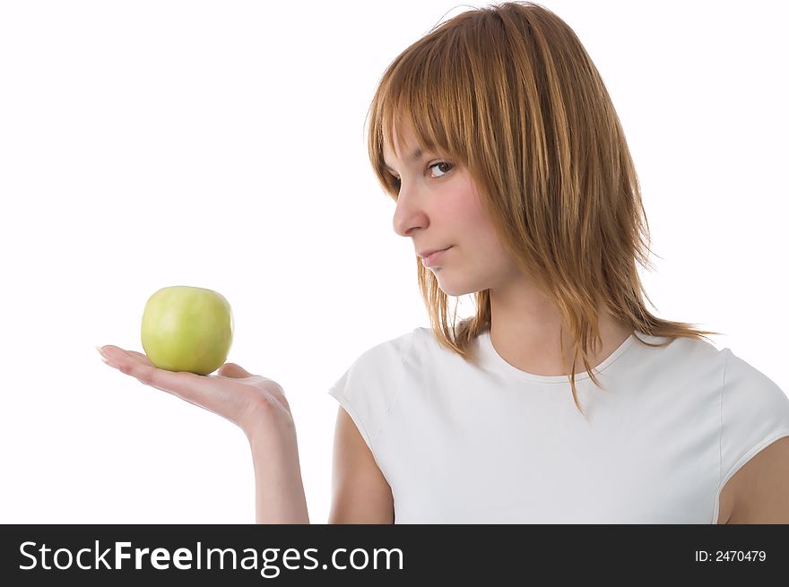The girl holds a green apple on a palm