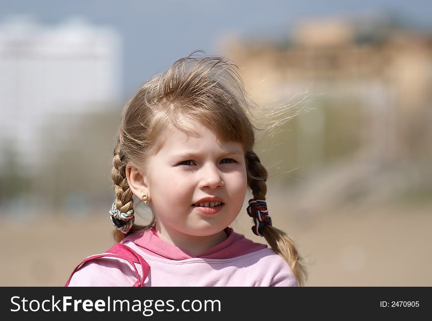 Portrait of the beautiful child in a urban street
