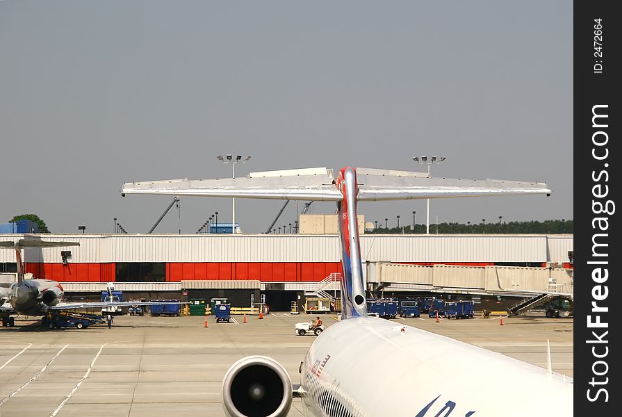 Large airline jets waiting at gates of a busy airport. Large airline jets waiting at gates of a busy airport