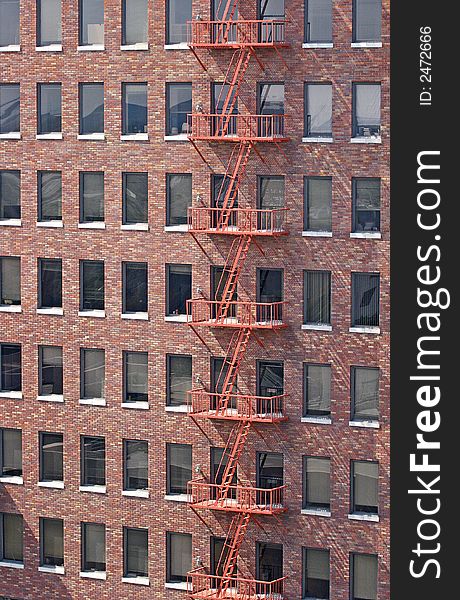 A red fire escape on an old red brick building