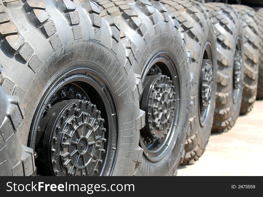 Automobile wheels built in a line on asphalt