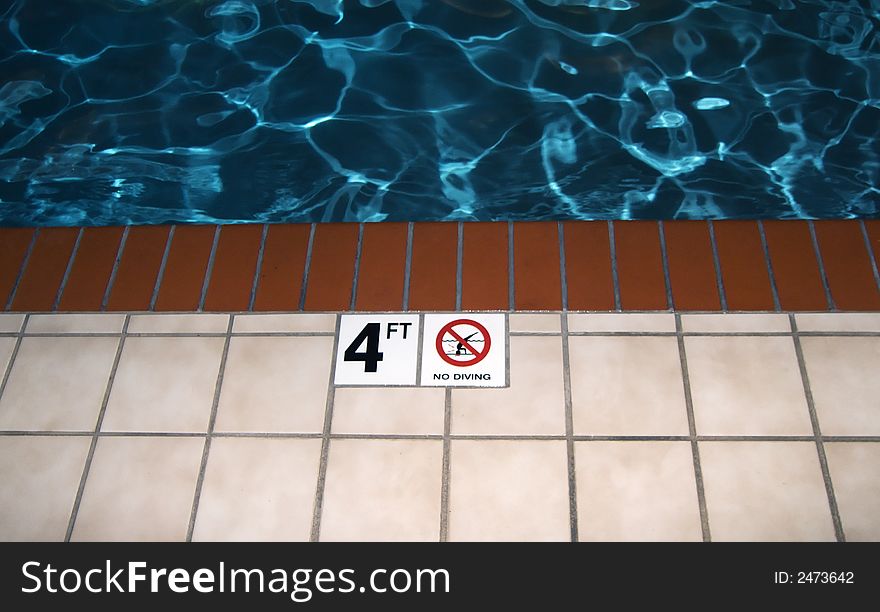 Photo of a no diving symbol next to a pool