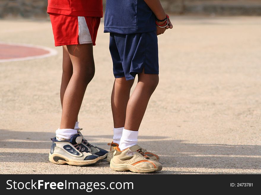 Two boys waiting their turn to play sport. A side shot of their lower bodies. Two boys waiting their turn to play sport. A side shot of their lower bodies