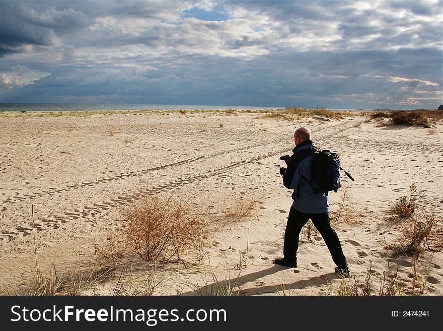 Walk on fresh air, productive leisure, a beautiful decline on seacoast Sandy seacoast on a decline, the phototourist in dynamical movement. Walk on fresh air, productive leisure, a beautiful decline on seacoast Sandy seacoast on a decline, the phototourist in dynamical movement