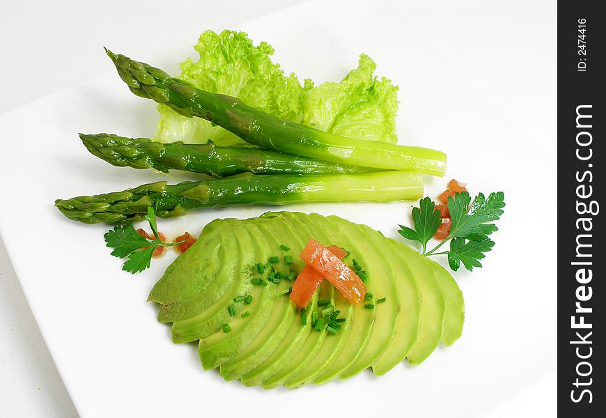 Green asparagus and avocado served on a platter