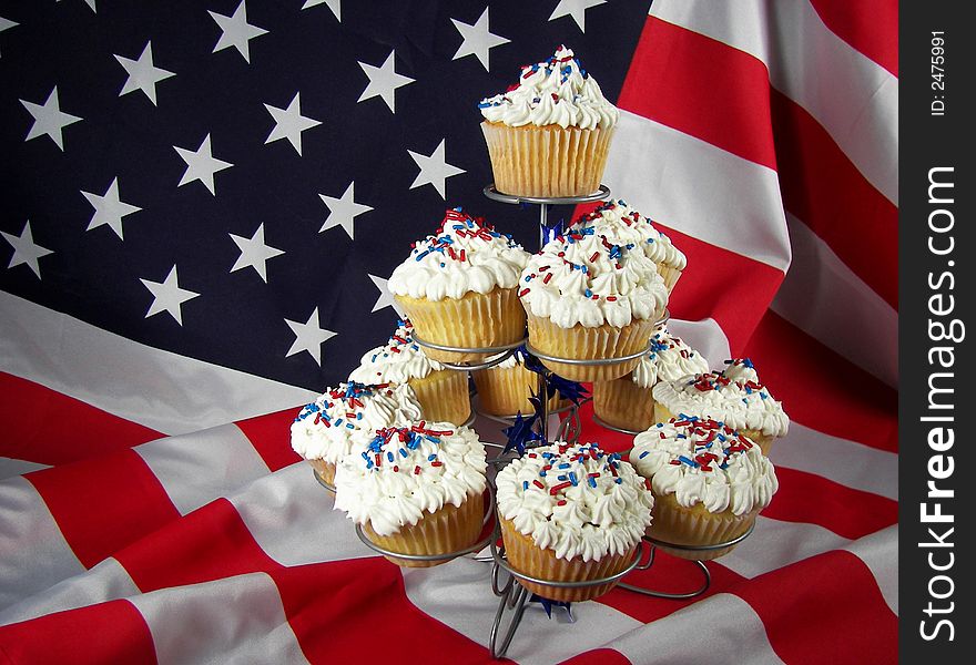 Dozen cupcakes arranged on a dessert tier with the USA flag as background. Dozen cupcakes arranged on a dessert tier with the USA flag as background