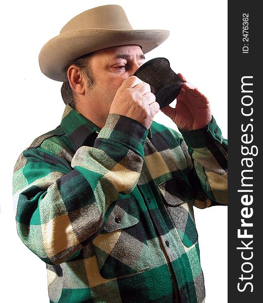 A man in a western hat drinking a cup of coffee,over white. A man in a western hat drinking a cup of coffee,over white
