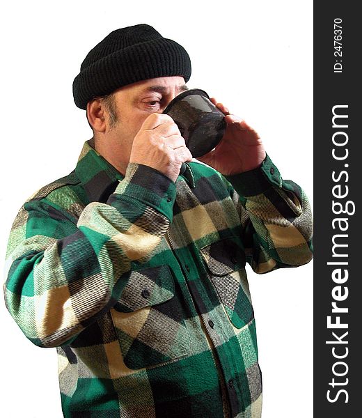 A man in a knit cap with a cup of coffee to his mouth,over white. A man in a knit cap with a cup of coffee to his mouth,over white.