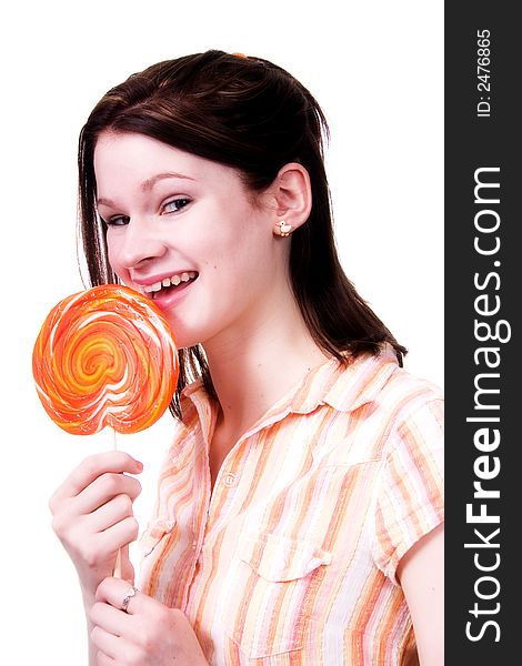 Attractive teen eating a giant lollipop. Isolated on white.
