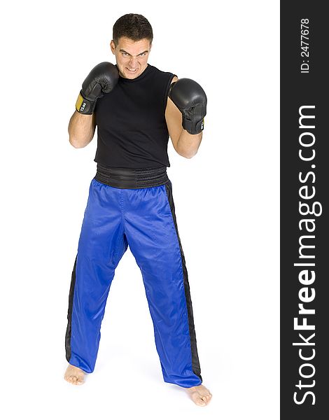 Angry young man in black boxing gloves, isolated on white in studio looking at camera. Whole body, front side. Angry young man in black boxing gloves, isolated on white in studio looking at camera. Whole body, front side.