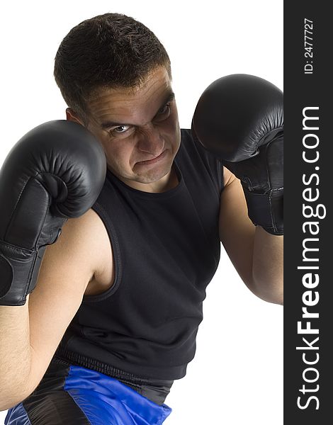 Angry young man in black boxing gloves with shady face, looking at camera. Isolated on white in studio. Angry young man in black boxing gloves with shady face, looking at camera. Isolated on white in studio.