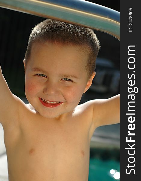 Boy standing in the pool, learning how to swim at an early age