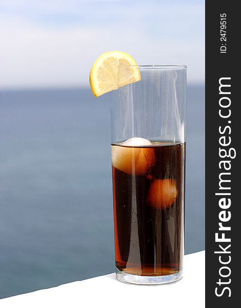 Glass of cola in front of the sea