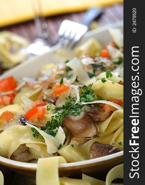 Yellow macaroni with mushrooms and cooked vegetables