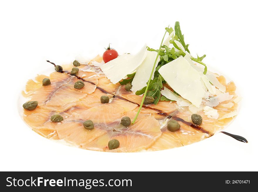 Fish carpaccio with cheese and herbs on a white plate