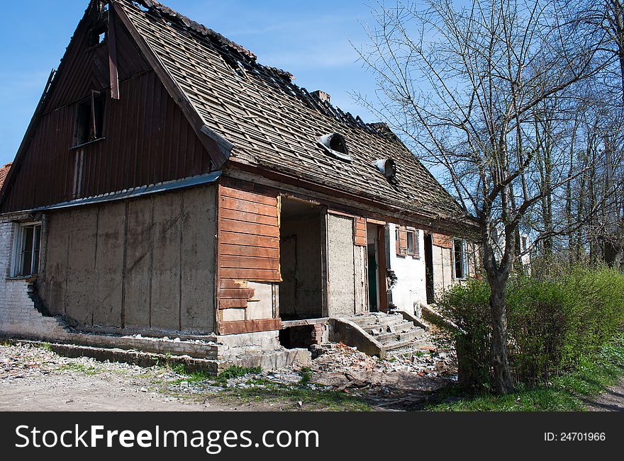 Old broken house in the street on sunny spring day