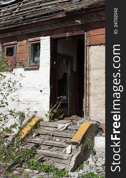 Door and room of abandoned broken house in sunny spring day