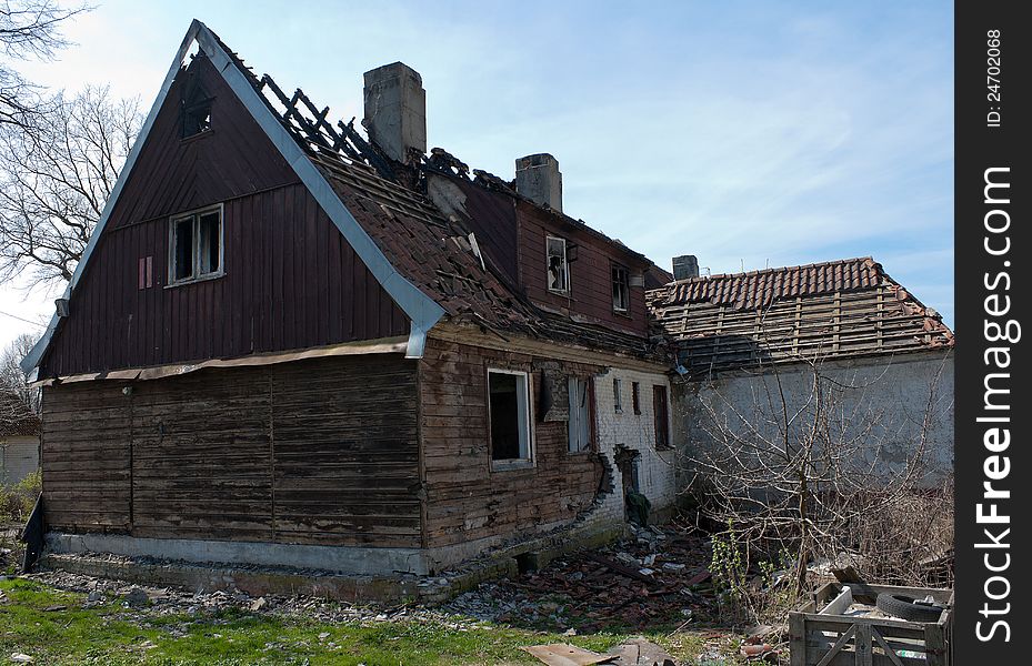 Abandoned broken house in the street on sunny spring day