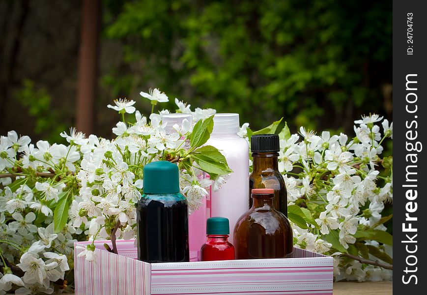 Bottles of aromatherapy oil and fresh cherry blossom - beauty treatment