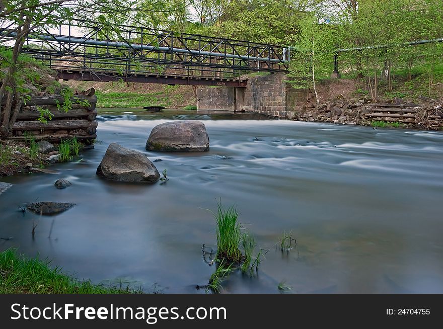 River landscape with the bridge stones and an old timbered felling