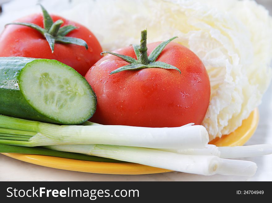 Salad ingredients, tomatoes, greens and cucumber