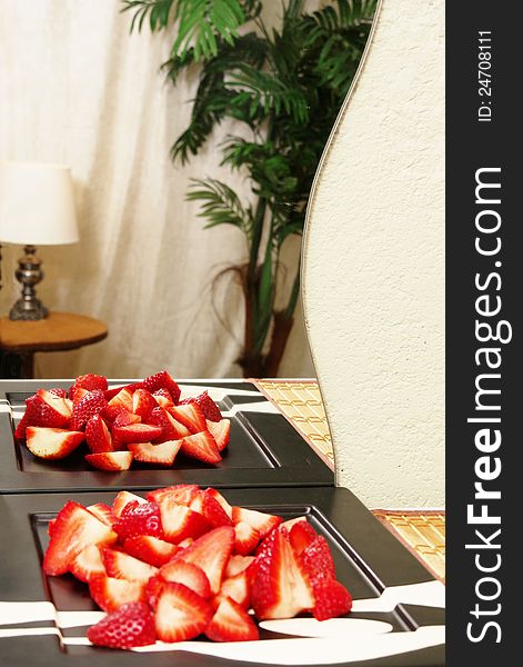 Sliced Strawberries reflected in hotel room mirror on bamboo mat. Sliced Strawberries reflected in hotel room mirror on bamboo mat.