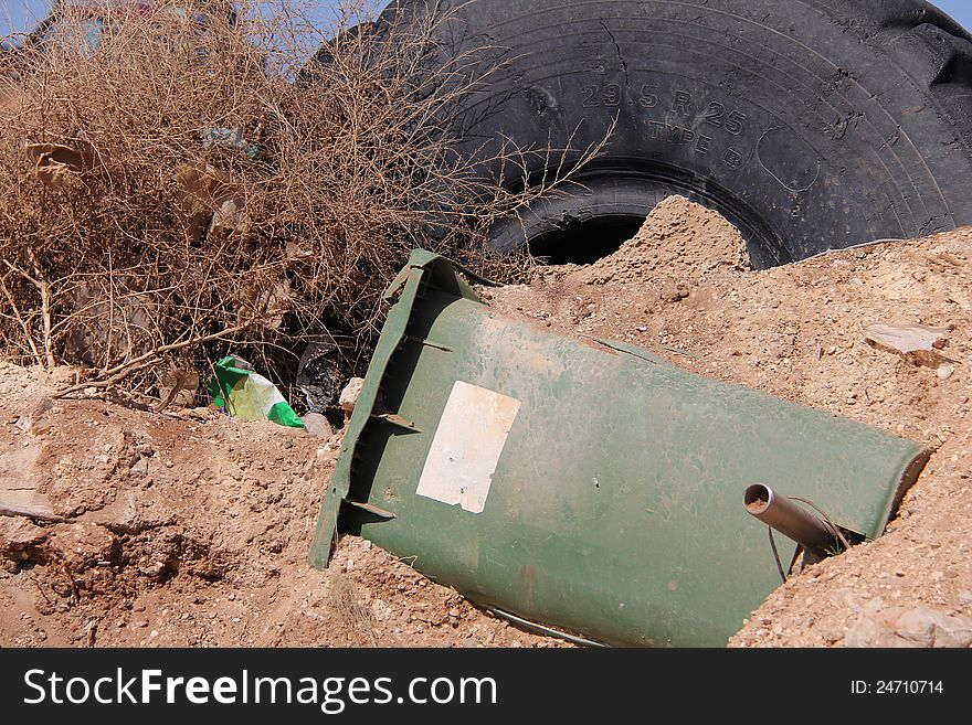 Rubbish dump rubber tire from a car or a tractor and a plastic garbage container