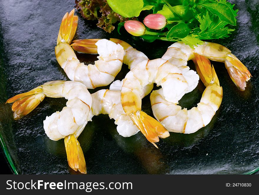 Boiled shrimps decorated with vegetables display on glass dish