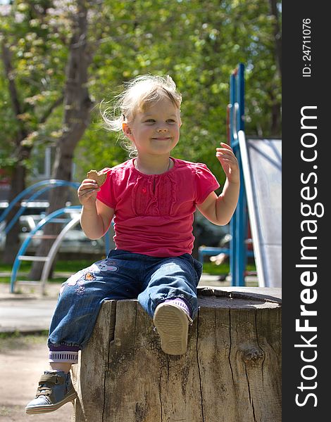 Little girl sitting on a stump and laughing. Little girl sitting on a stump and laughing